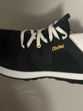 OluKai women’s Black Sneaker with White Laces and Gold Logo